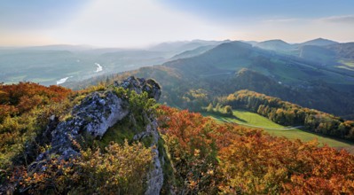 View of an autumnal forest from the Gisliflue, behind the Jura foothills with Wasserfluh and