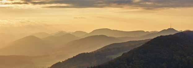 View of an autumnal forest from the Gisliflue, behind the Jurassic foothills with the water fluh in