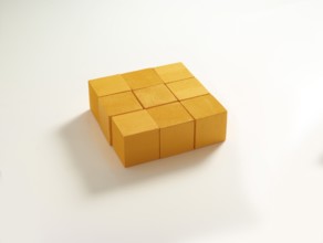 9 yellow wooden cubes against a white background