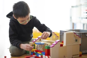Boy, 6 years, glasses, multi-ethnic, plays with Lego, concentrates, constructs, builds, Stuttgart,