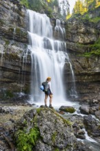 Young woman in front of Cascata di Mezzo waterfall, long exposure, Vallesinella, Brenta, Trentino,