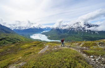 Climbers on a hiking trail, Slaughter Ridge Trail, view of snowy mountains and turquoise lake Kenai