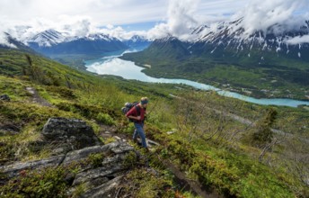 Climbers on a hiking trail, Slaughter Ridge Trail, view of snowy mountains and turquoise lake Kenai