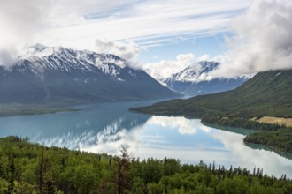View of snowy mountains in spring and turquoise Kenai Lake with reflection, Slaughter Ridge Trail,