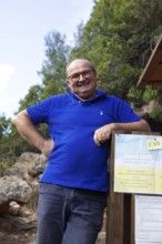 Corsican man, 67 years old, checks the entrance to the Genoese Tower of Porto, Ota, west coast of