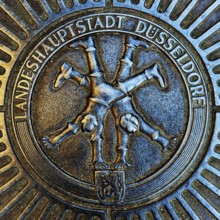 Manhole cover with classic depiction of the racket, landmark of the state capital Düsseldorf, North