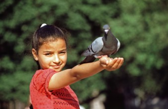 Girl lets dove eat out of her hand, Placa de Catalunya, Barcelona, Spain, June 1999, vintage,
