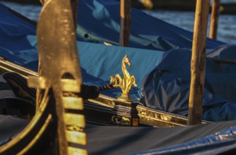 Arch iron, ferro and gondola decoration of a gondola at sunrise, Venice, Veneto, Italy