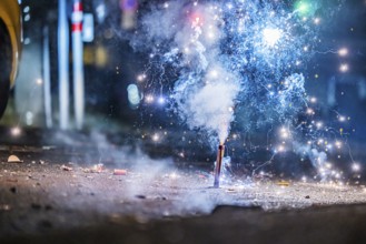 Burnt off fireworks are lying on the street, firecracker smoke produces smoke. New Year's night on