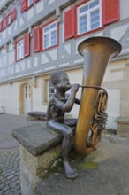 Sculpture boy with tuba by Guido Messer 1991, modern art, bronze sculpture, playing music, tuba,
