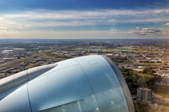 An impressive view of the city and the blue sky opens up from the aircraft turbine, a view from an