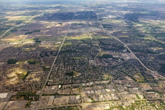 Vast urban areas with a distinctive striped pattern under a blue sky, view from an airplane of the