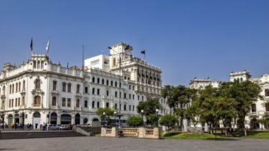 Impressive colonial building on an open square with trees and clear sky, Downtown Lima in Peru