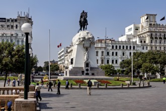 Equestrian statue surrounded by walkers, against a backdrop of colonial architecture, Downtown Lima