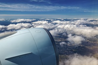 Aircraft engine above clouds overlooking the city, In an airplane above the clouds
