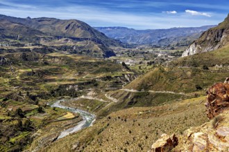 River valley with terraces and mountains under sweeping skies, the landscape of the Colca Canyon in