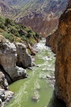 River with green water surrounded by steep rock faces, The landscape of the Colca Canyon in the
