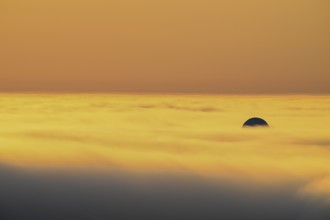 View from Mount Domen. Thick sea fog hangs over the Barents Sea and the midnight sun shines in an