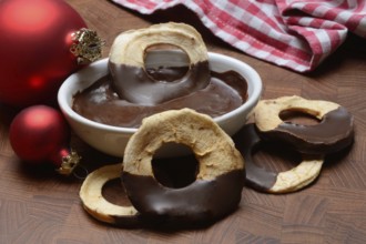 Apple rings, coated with chocolate, chocolate glaze in bowl