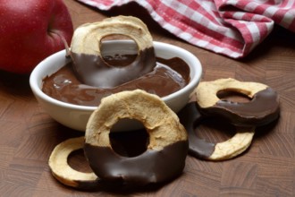 Apple rings, coated with chocolate, chocolate glaze in bowl