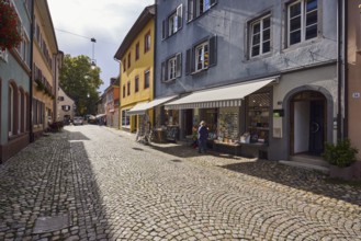 Historic residential and commercial buildings, houses, façade with windows, shutters, awnings and