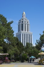 Tall white building in the park with carriages in the foreground and clear sunny sky, Sheraton