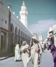 Leading blind person in street, Tripoli, Libya, North Africa 1956 minaret of Ahmed Pasha Karamanli