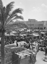 Market stalls and people in market souk in media old town area of Tripoli, Libya, North Africa 1956