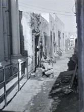 Workers with metal pots in narrow alleyway street in old town medina, Tripoli, Libya, North Africa