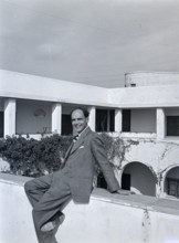Smartly dressedBritish man sitting on hotel wall of Arabic style building, Tripoli, Libya, North
