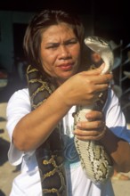 A woman presents a python in Damnoen Saduak near Bangkok, Thailand, December 2002, vintage, retro,