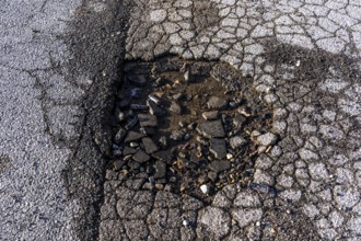 Pothole, asphalt surface, floor, with many small cracks, roadway, parking lot