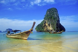 Rocks in the sea and longtail boats on Pranang Cave beach, two years in front of the tsunami,