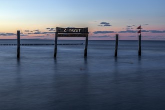 Wooden sign in the sea with inscription Zingst, long exposure, evening light, Zingst,