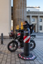 Passers-by at the security barrier made of massive bollards at the Brandenburg Gate passage,
