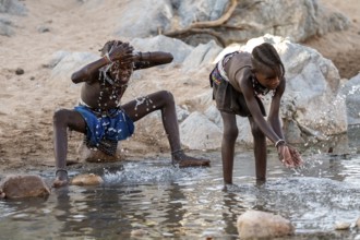 Himba child washing with water on a river, traditional Himba, Kaokoveld, Kunene, Namibia