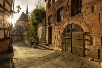 Historic alley with half-timbered houses and church in sunlight with a quiet atmosphere, The