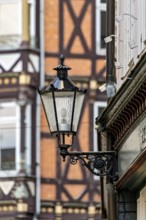 Nostalgic lantern in front of a half-timbered house with distinctive architectural patterns and