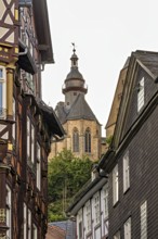 Detailed architecture shows half-timbered houses and a church above the roofs, The historic old