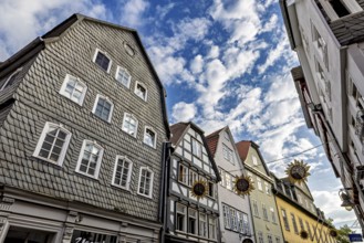 View of half-timbered houses under a vivid blue sky with decorative sun ornaments, The historic old