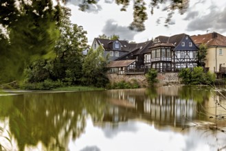 Half-timbered houses on the lake with dramatic clouds and reflections in the water, The historic