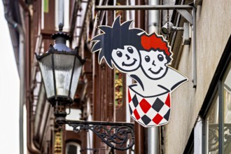 Lantern next to a colorful advertising sign in urban areas with traditional building facades, The