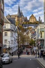 City life in Marburg with a mix of modern and historic buildings and a church in the background,