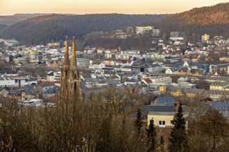 View of a town with a church and surrounding hills at sunset, view of the city of Marburg with the
