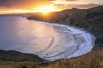 Wairarapa coast at sunset. Sea, mountains, backlight. Castlepoint, Wairarapa Coast, Wellington