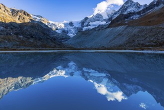 The Moiry glacier and mountain peaks are reflected in Lac de Chateaupre, Val d'Anniviers, Valais