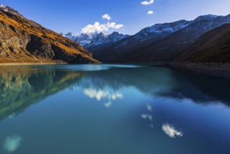 The turquoise Lac de Moiry reservoir, behind the peaks of the Grand Cornier, Tete Blanche and