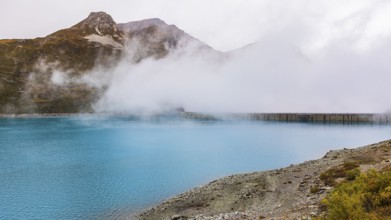 Fog rises over the dam of the Lac de Moiry Reservoir, Val d'Anniviers, Valais Alps, Canton of