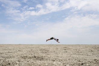 Abstract, man jumping horizontally at the Etosha pan, salt pan, Etosha National Park, Namibia