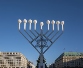 Large Hanukkah chandelier at the Brandenburg Gate in daylight, sign of lively Jewish life, symbolic